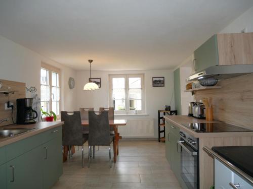 a kitchen with a table and a dining room at Ferienhaus Juule in ruhiger Lage, Terrasse, WLAN in Krummin