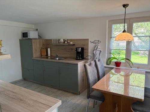 a kitchen with green cabinets and a table and a window at Ferienhaus Juule in ruhiger Lage, Terrasse, WLAN in Krummin