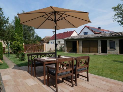 a table and chairs with an umbrella on a patio at Ferienhaus Juule in ruhiger Lage, Terrasse, WLAN in Krummin