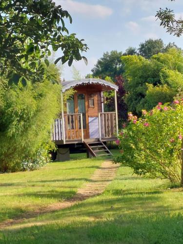 une cabane en bois au milieu d'une cour dans l'établissement Les roulottes de la Brauderie, à Les Varennes