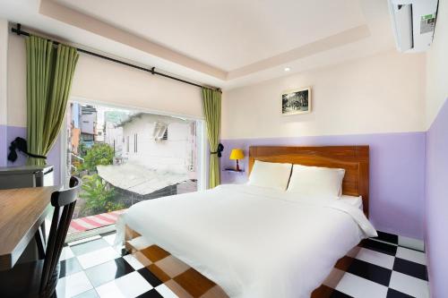 une chambre avec un lit blanc et une fenêtre dans l'établissement Ahu Hotel & Apartment, à Hô-Chi-Minh-Ville