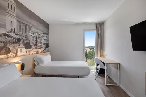 a hotel room with a bed and a chair and a desk at B&B HOTEL Girona 3 in Salt