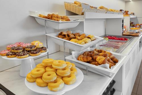 a bakery with several plates of donuts and other pastries at B&B HOTEL Girona 3 in Salt