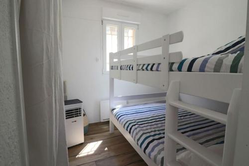 une chambre avec deux lits superposés et une fenêtre dans l'établissement T2 jardin, 100m de la plage, à Sanary-sur-Mer