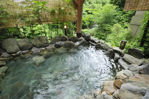 a pool of water with rocks in a backyard at Koorogirou in Kaga