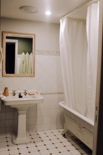 La salle de bains est pourvue d'un lavabo, d'une baignoire et d'un rideau de douche. dans l'établissement Mas de Gratte-Semelle 