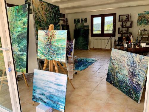 a room full of paintings on display in a room at Villa Marlena, Calonge, Costa Brava,1 luxe private studio-appartement with private pool in quiet area, adults only, Catalonia, Spain in Calonge