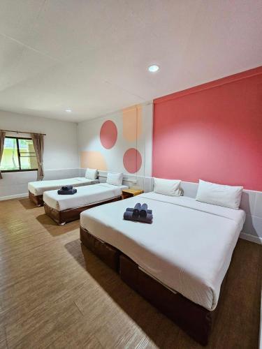 a bedroom with two beds and a red wall at Malibu Samed Resort in Ko Samed
