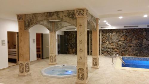 a large bathroom with a tub and a stone wall at Комплекс Стара Плиска in Pliska