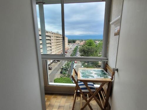 Cette chambre dispose d'une table et offre une vue sur la rue. dans l'établissement Location de Vacances Saint Cyprien, à Saint-Cyprien
