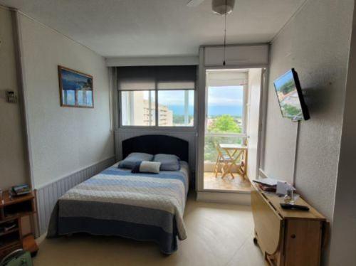 une chambre avec un lit et une grande fenêtre dans l'établissement Location de Vacances Saint Cyprien, à Saint-Cyprien