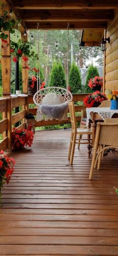 a porch with a swing and a table and chairs at Siedlisko pod lipą in Józefów