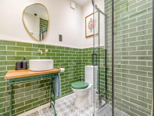 a green bathroom with a sink and a toilet at Papist Hall Cottages in Barrow upon Humber