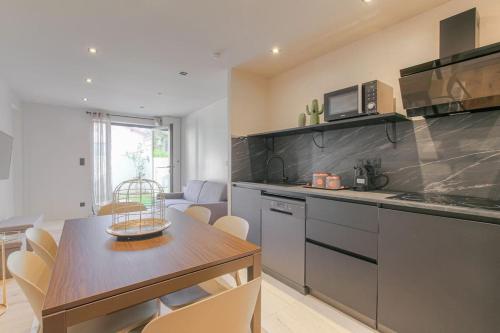 une cuisine avec une table et un comptoir dans l'établissement T3 spacieux en duplex, 2 chambres, Villeurbanne, à Villeurbanne
