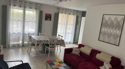 un salon avec un canapé rouge et une table dans l'établissement Le Mas Cayrel, à Uzès