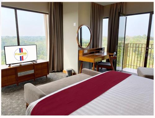 a bedroom with a bed and a desk and a mirror at Famvida Hotel Lubuklinggau in Lubuklinggau