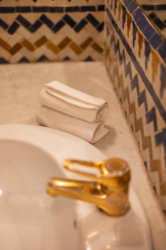 a bathroom sink with a gold faucet and a towel at LUXURY apartment in Marrakesh