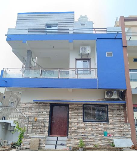 ein Gebäude mit einem Balkon und einer roten Tür in der Unterkunft PATEL,s Home Stay in Navgam