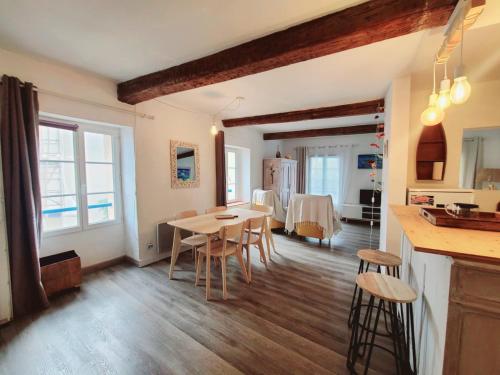 une cuisine et une salle à manger avec une table et des chaises dans l'établissement Appartement spacieux T2 avec vue mer d'exception au pied des plages, à Collioure