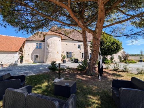 a large stone house with a tree in the yard at Espace st andre in Douadic