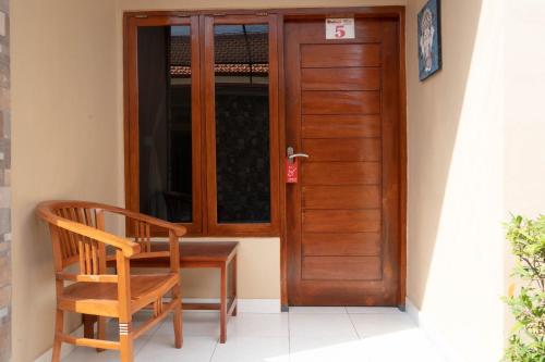 a wooden door with a chair next to a desk at RedDoorz near Buleleng Harbour 2 in Singaraja