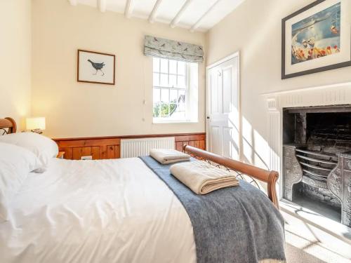 a bedroom with a bed and a fireplace at Papist Hall Cottages in Barrow upon Humber