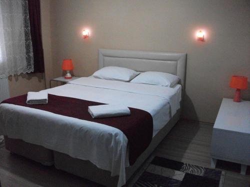 una camera da letto con un letto grande con due asciugamani sopra di Ernur Pension a Çanakkale