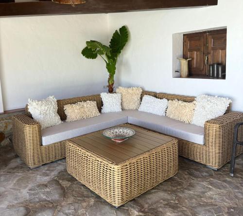 a living room with a wicker couch and a table at Tierratlanta Suites in Zahara de los Atunes