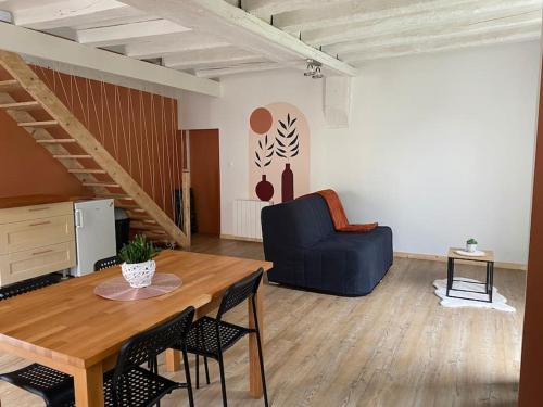 un salon avec une table et un canapé bleu dans l'établissement Petite maison de bourg, à Noyers