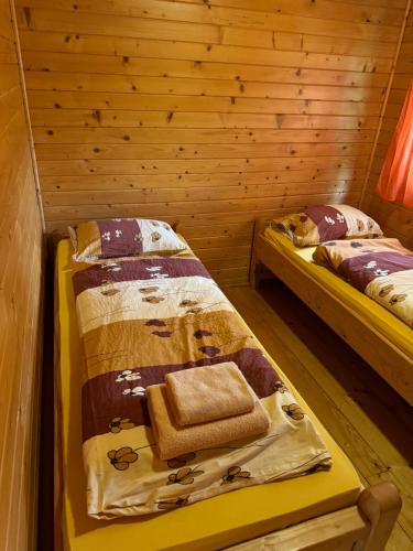 a room with two beds in a log cabin at Domki Winnica Maria Anna in Wyżne