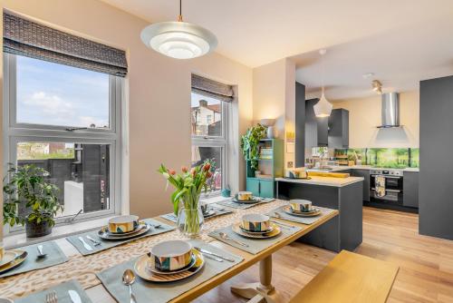 a kitchen and living room with a table with dishes on it at Eco Friendly Luxury Townhouse with Parking in Norwich
