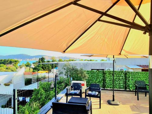 a large umbrella on top of a balcony with chairs at Sea Coast Apartments in Bar
