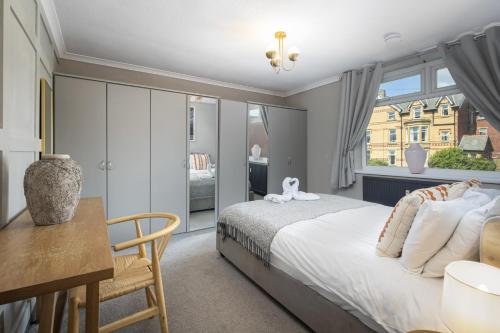 a bedroom with a bed and a desk and a window at Bentinck Residence by Sasco Apartments in Lytham St Annes