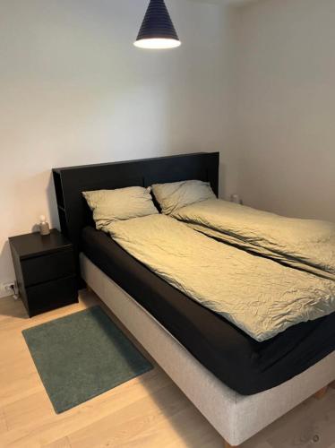 a bedroom with a bed with a black headboard at Moderne leilighet fra 2019 in Sandnes