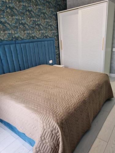 a bedroom with a bed with a brown comforter at 2 комнатная квартира in Sumqayyt