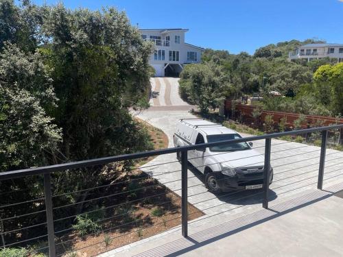 a white van parked on a balcony of a house at Cola Beach Nomads Nook in Sedgefield