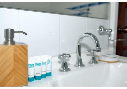 eine Küchenspüle mit Zahnbürsten und einem Wasserhahn in der Unterkunft Cozy Mountain Cottage in Katoomba