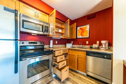 a kitchen with wooden cabinets and stainless steel appliances at Metro PHX 1bd Exterior Entry with heated pool, bbq, dog park, bbq PETS ALLOWED in Phoenix