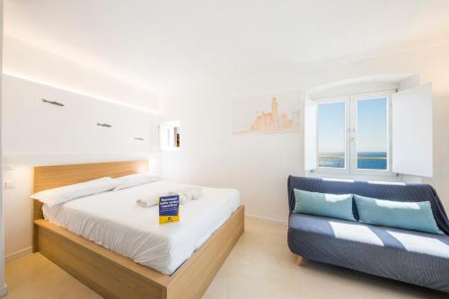 a bedroom with a bed and a blue couch at CasaViva - Elegant Seaview Studio in Camogli in Camogli