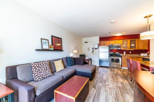 a living room with a couch and a kitchen at Metro PHX 1bd Exterior Entry with heated pool, bbq, dog park, bbq PETS ALLOWED in Phoenix