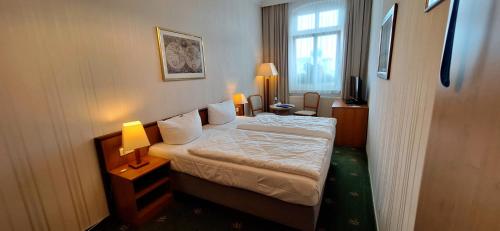 a hotel room with a bed and a window at Hotel Meereswelle - Anno 1875 in Ahlbeck