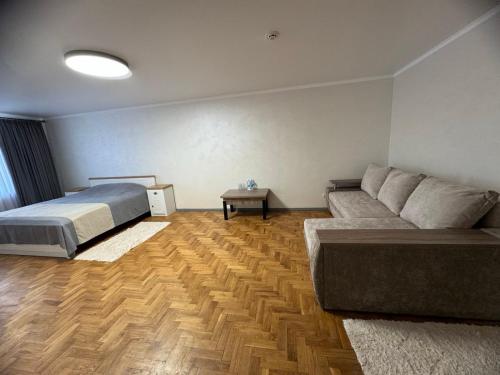 a bedroom with a bed and a couch and a table at In hotel in Kamianets-Podilskyi