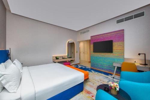 a hotel room with a bed and a tv at La Quinta by Wyndham Abu Dhabi Al Wahda in Abu Dhabi