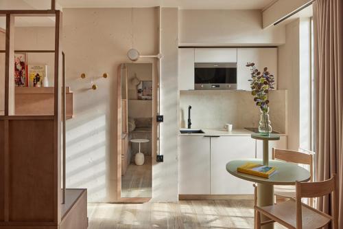 a kitchen with a table and a small table in a room at Buckle Street Studios by Locke, Aldgate in London