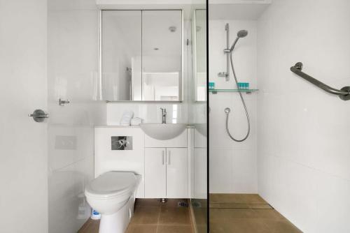 a white bathroom with a toilet and a shower at Harbourside #76 in Sydney