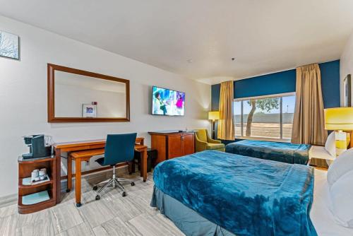 a hotel room with two beds and a desk at Metro Extended Stay - Tempe - 2 Full Beds in Tempe