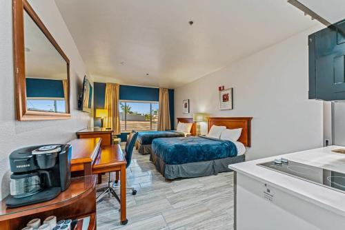 a hotel room with a bedroom with a bed and a desk at Metro Tempe Extended Stay - 2 Full Beds in Tempe