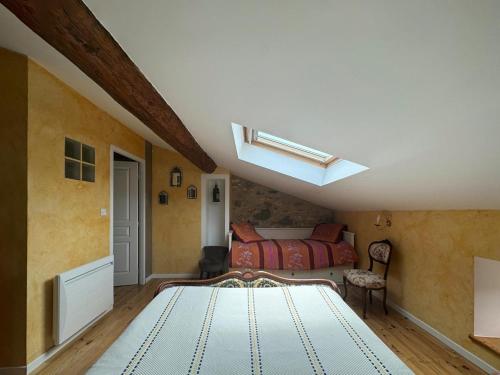 a bedroom with a bed in a room with a skylight at L'Oustal de l'Annetta Chambres et Tables d'Hôtes in Comus