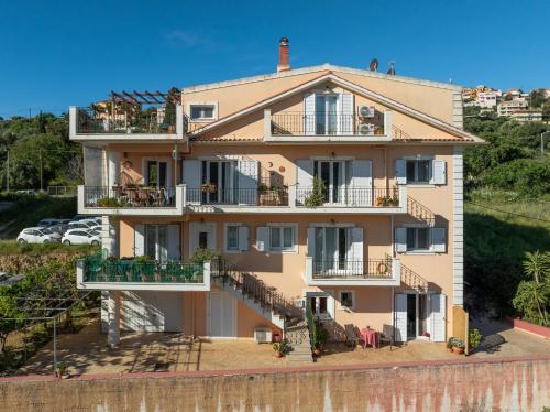 an apartment building with balconies and tables at Nefeli seaview apartment in Argostoli