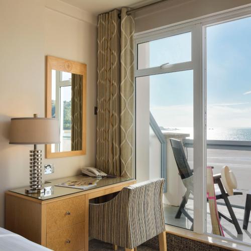 a hotel room with a desk and a window at Golden Sands in St Brelade